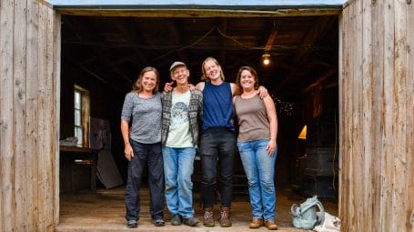 four women smiling in barn entrance