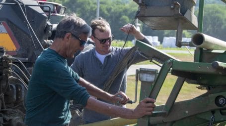 two men working on hay baler - dairy farm Pawlet Vermont