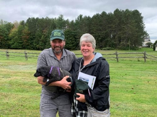 couple with dog in farm field on Missisquoi River
