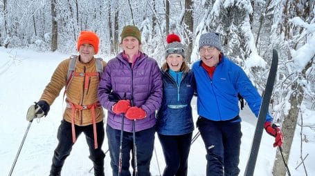 Four laughing cross-country skiers at Prospect Mountain