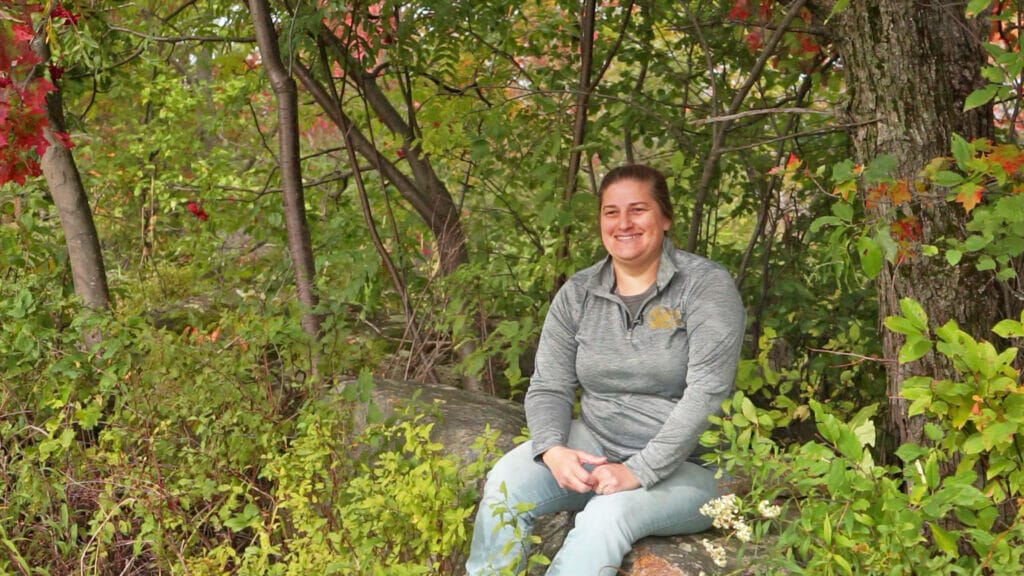 Jessica siting in her bird-friendly maple woods in Richford Vermont