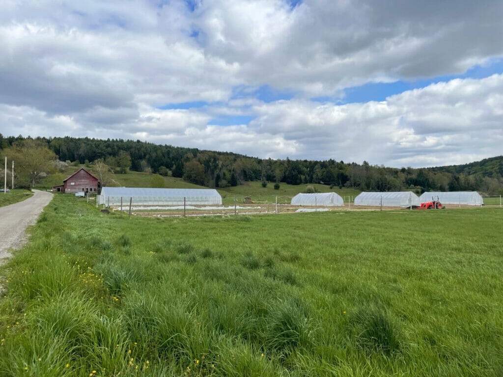 Long distance shot of farm with barn and hoop-houses growing vegetables. Berlin Vermont. Glinnis Hill Farm