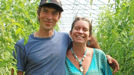 smiling man and woman in greenhouse - farmers win award