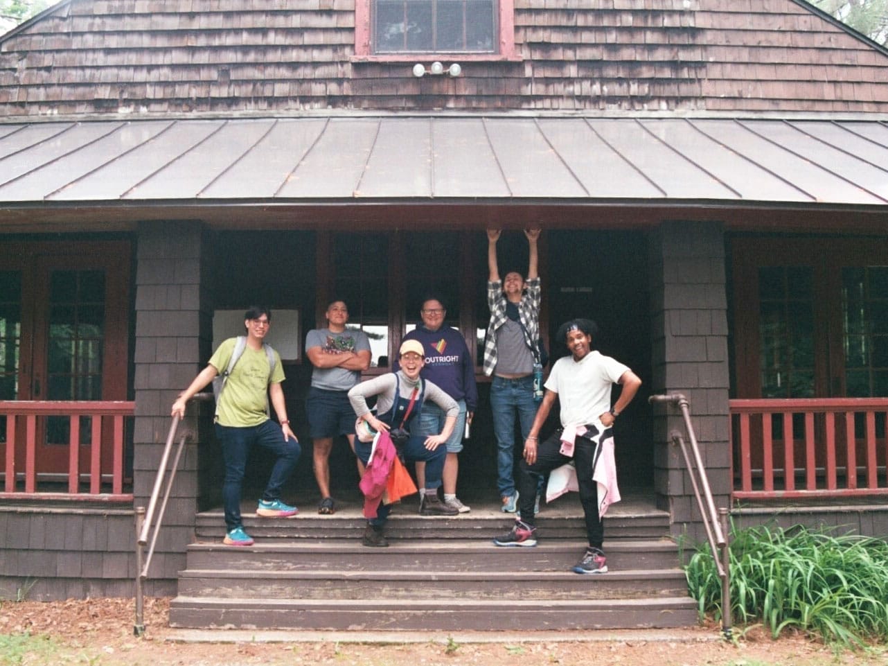 A group of six young people in the Camp Outright program on a cabin porch .