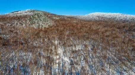 drone image of snowy ridgeline with forest in Richford Vermont