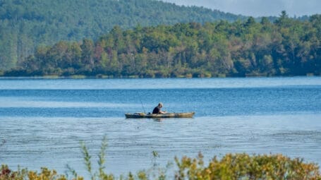 person fishing from a kayak on large pond, Berlin Vermont